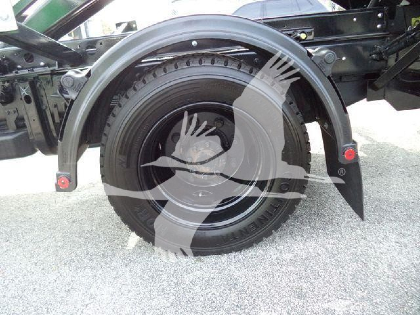Wheel well and tire on a 2023 Chevrolet Silverado 6500HD rolloff truck showing fender and suspension components.