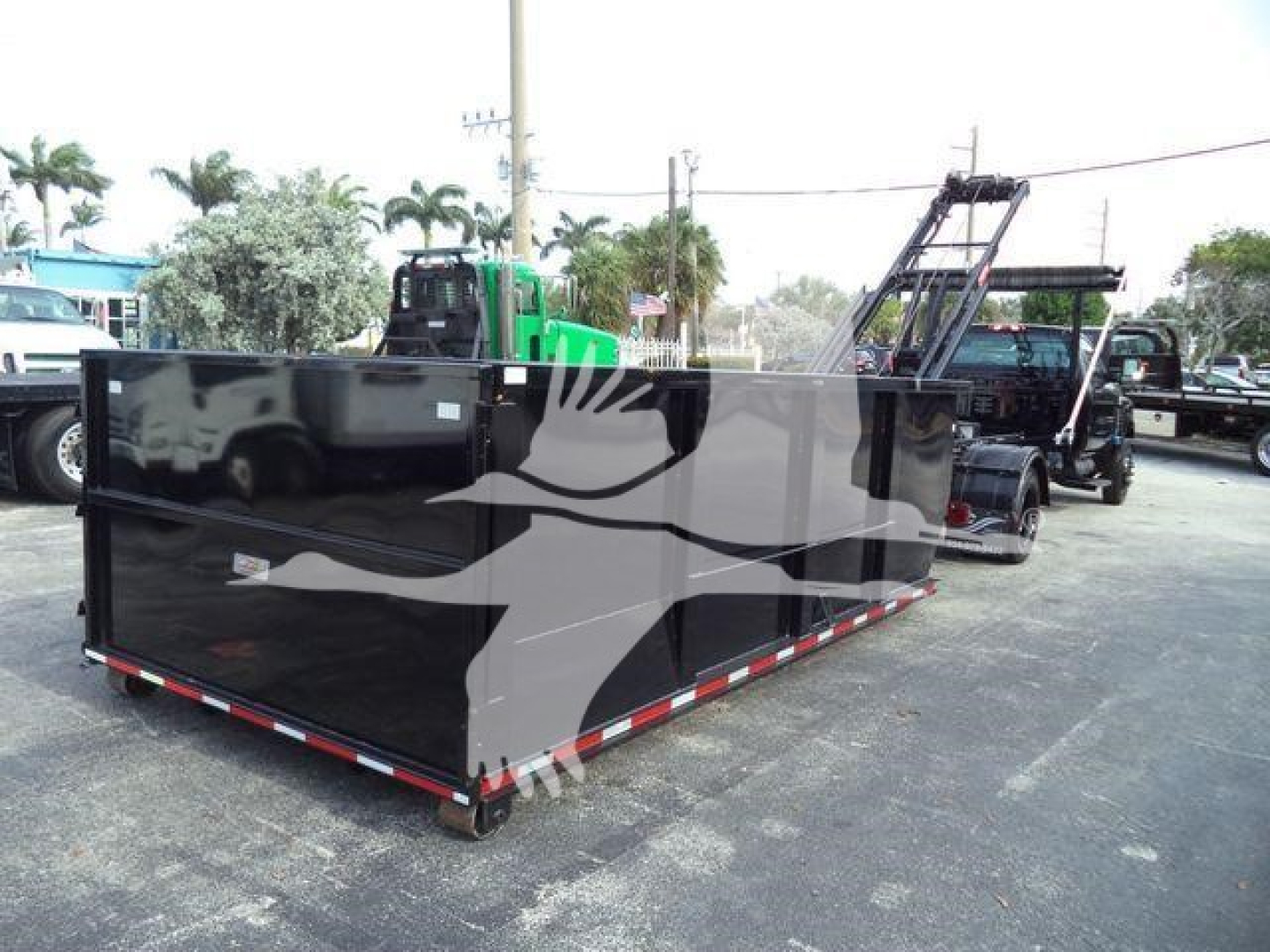 Rear view of a new 2023 Chevrolet Silverado 6500HD roll-off truck body in a dealership lot.