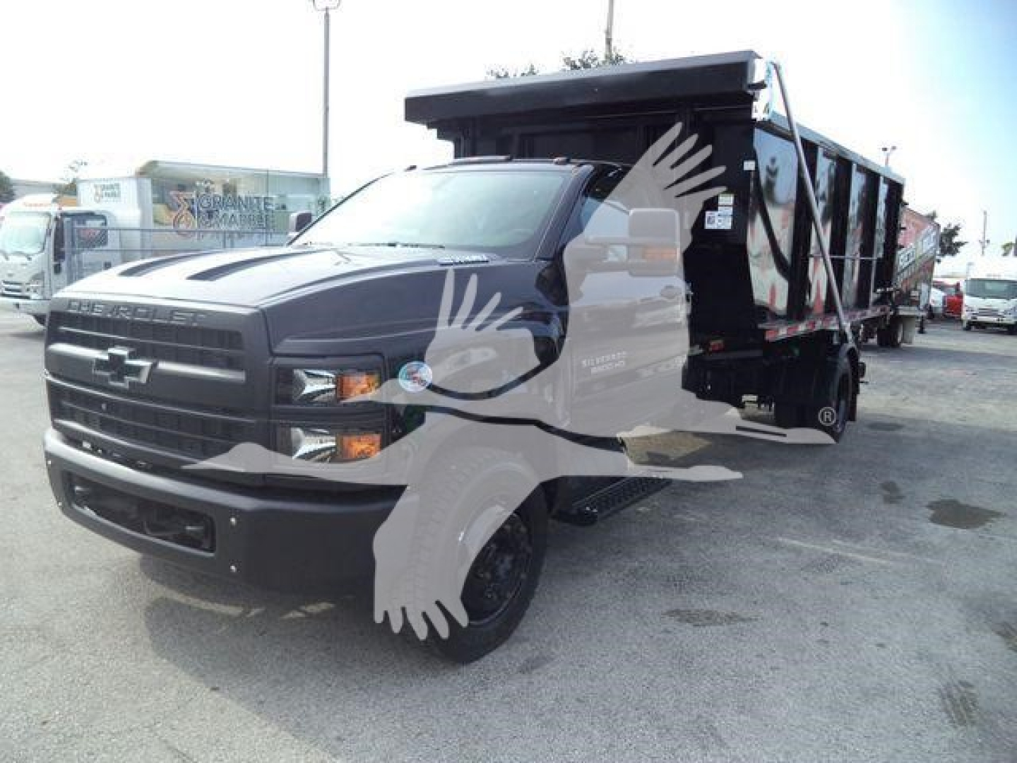 Chevrolet Silverado 6500HD dump truck in serviceable condition showing front grille and dump bed with logo and decals.