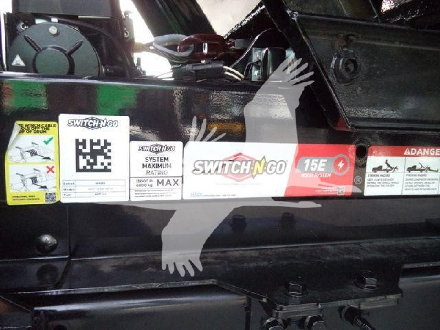 Chevrolet Silverado 6500HD engine bay area with warning decals and Switch-N-Go system labels on the side of a black truck bed.