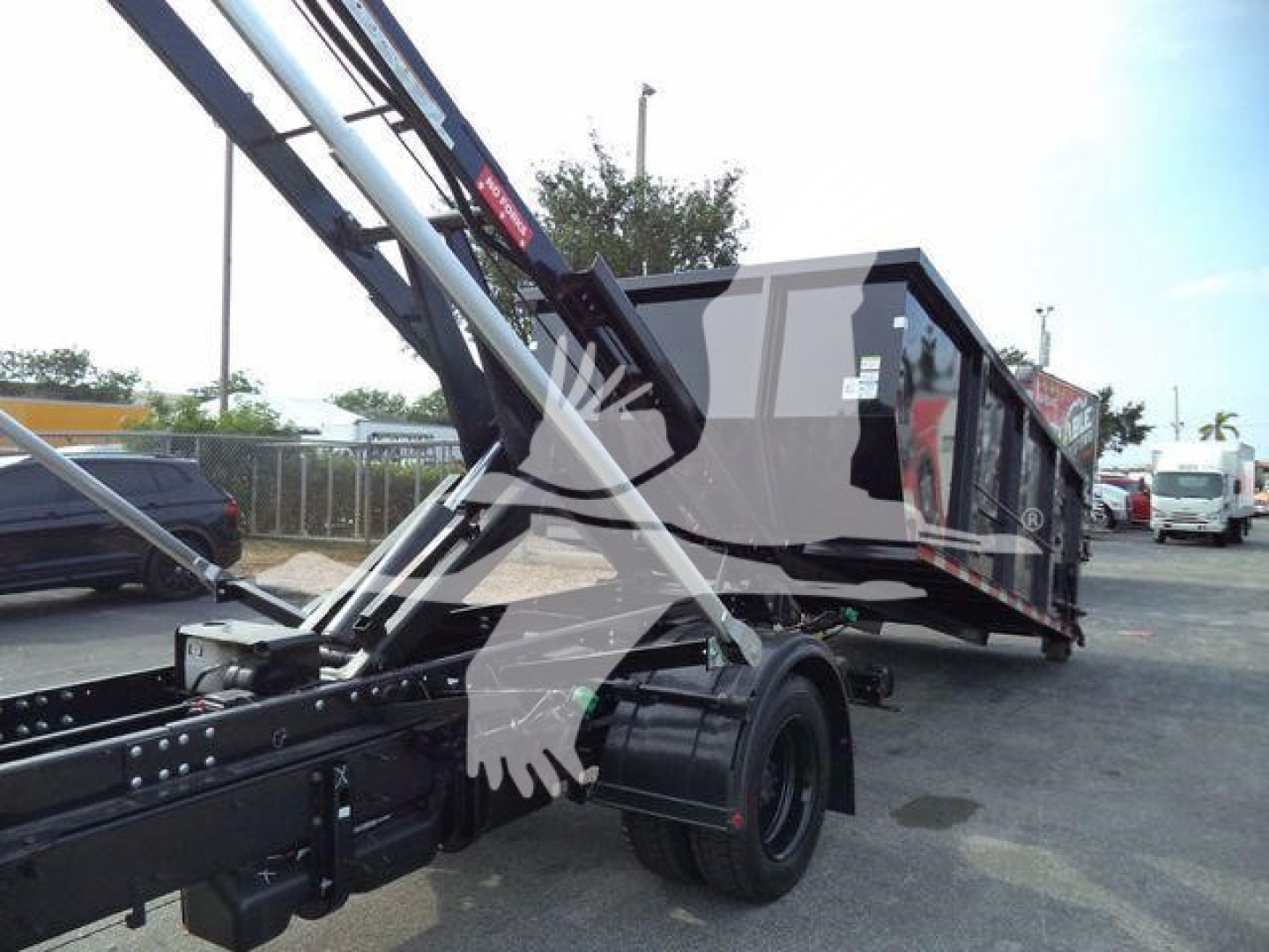 Truck chassis and roll-off bed showing hydraulic arms and cab in a new Chevrolet Silverado 6500HD roll-off truck.