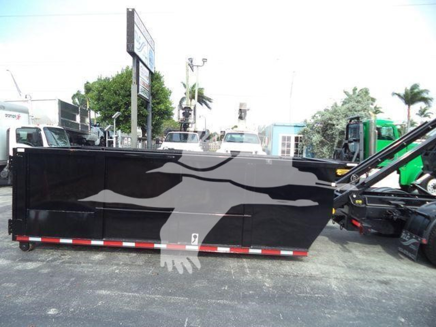 Truck bed with graphic design showing a large bird or eagle silhouette on a black surface, side view, roll-off container attachment visible at right