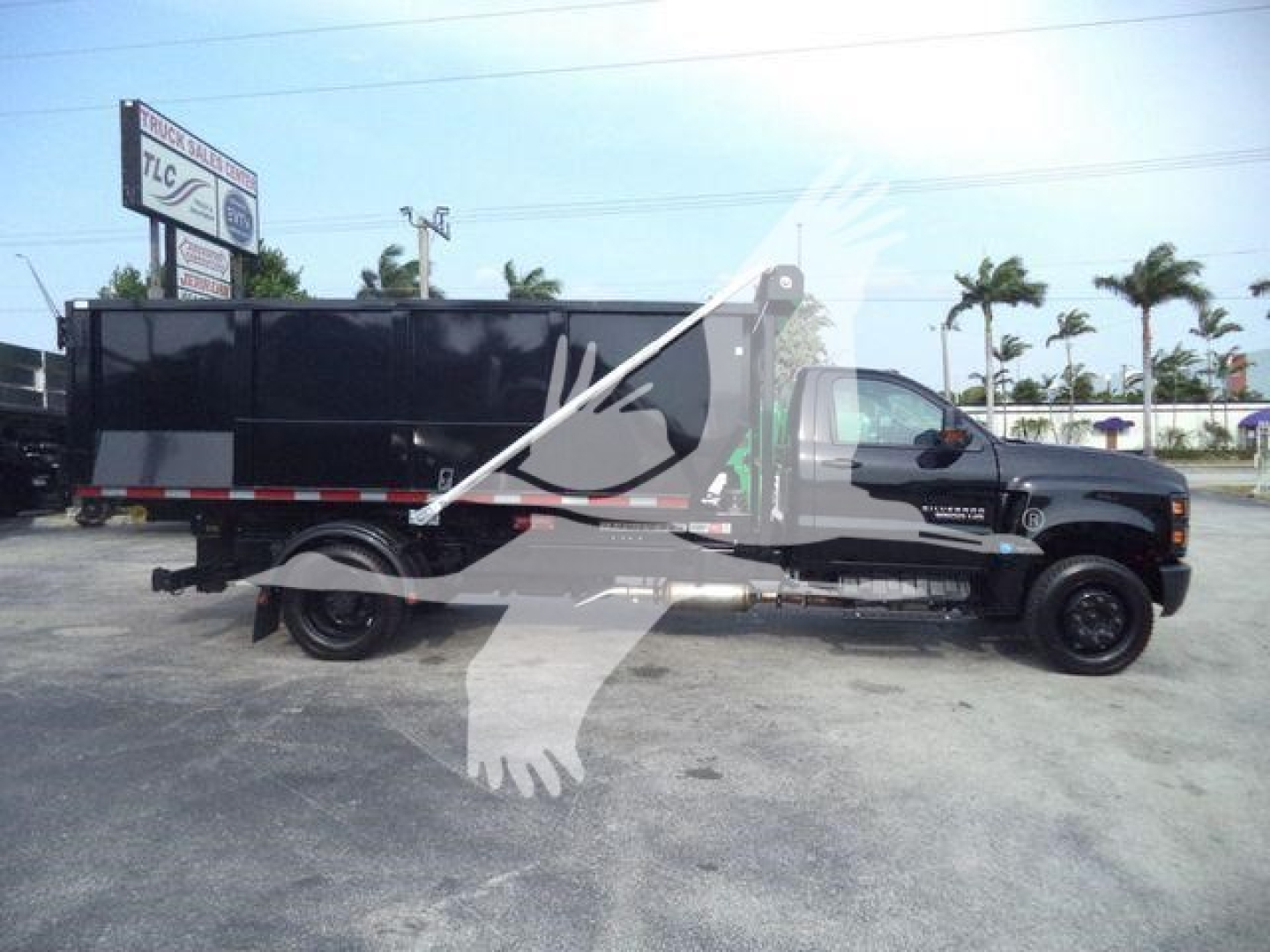 Chevrolet Silverado 6500HD roll-off truck side view showing dump bed and chassis with branding