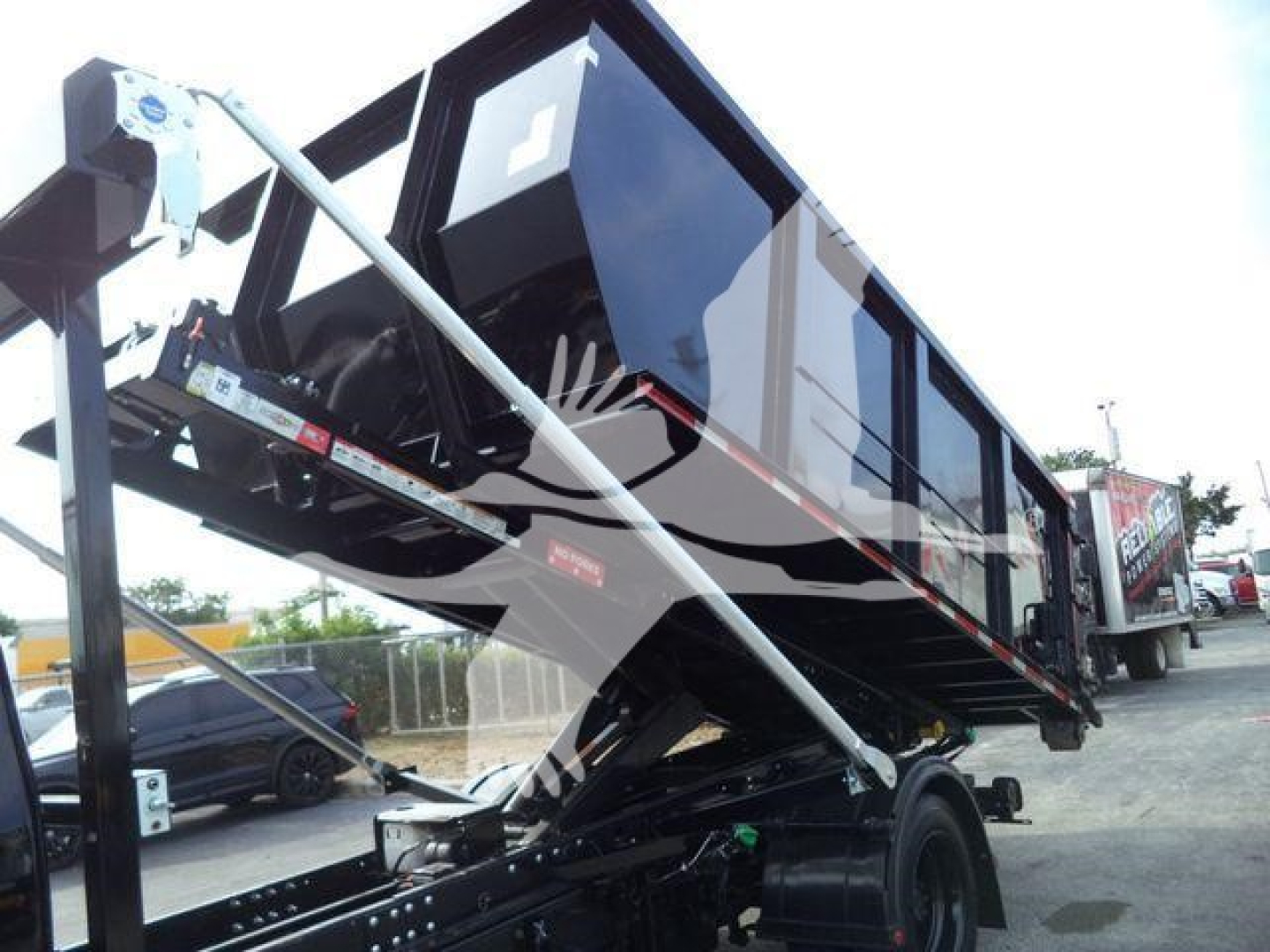 Truck bed or container hopper mounted on a raised hydraulic arm attached to a Chevrolet Silverado chassis, showing a roll-off configuration.