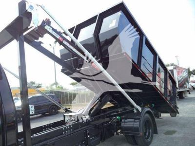 Truck dump bed with hydraulic tilt mechanism and cab shown as a Silverado chassis. Text on image is limited to listing details such as stock number J05883FM and category Rolloff.