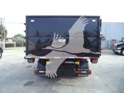 Rear view of a 2023 Chevrolet Silverado 6500HD roll-off truck showing the cargo bed and hitch area.