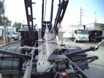 Front view of 2023 Chevrolet Silverado 6500HD roll-off truck showing hydraulic controls and hoist mechanism.