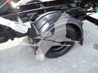 Truck chassis and rear wheel assembly showing wheel, suspension, and rolloff container mounting area on a 2023 Chevrolet Silverado 6500HD.