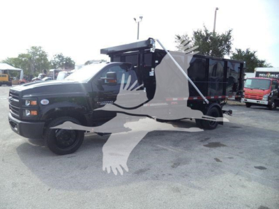 Chevrolet Silverado 6500HD dump truck/roll-off body showing cab and long cargo bed with hydraulic setup.