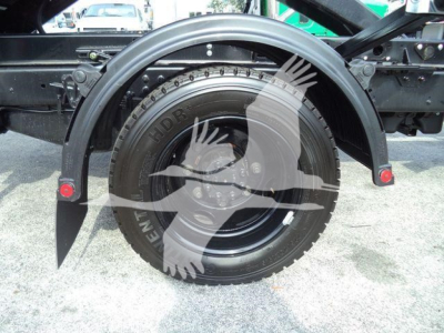 Rear wheel area of a 2023 Chevrolet Silverado 6500HD rolloff truck showing spare tire and fender, stock number J05883FM.