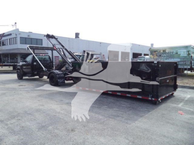 Chevrolet Silverado 6500HD roll-off with black-and-gray module in a parking lot, truck in background, stock number J05883FM