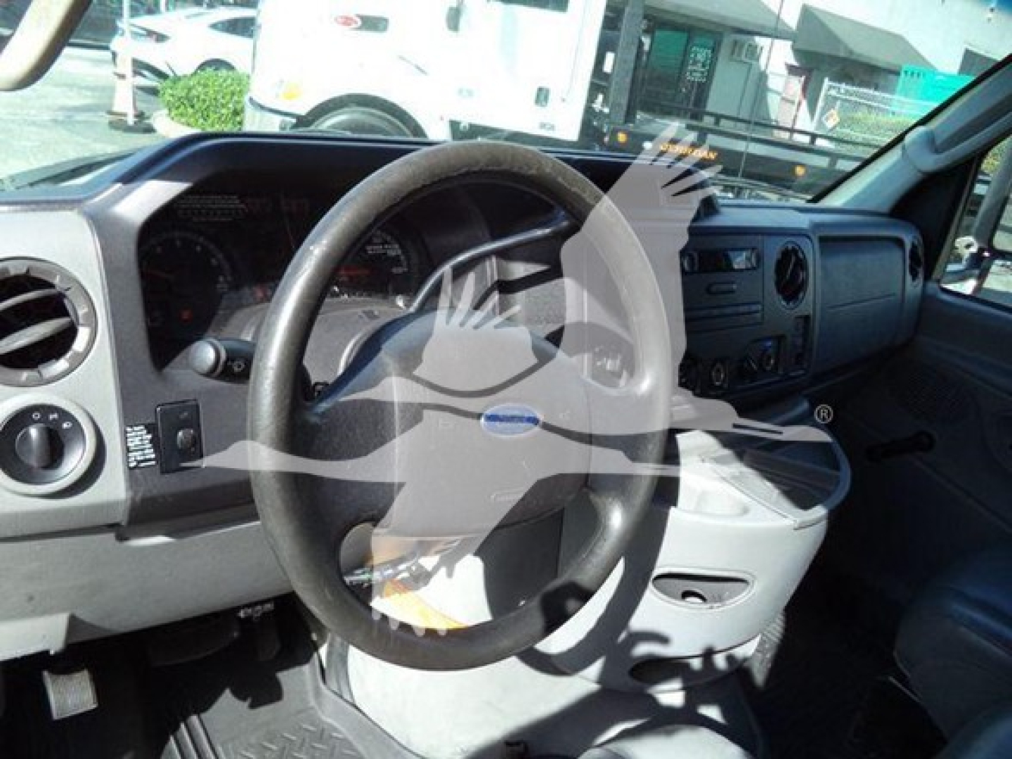 Ford E-Series dashboard and steering wheel in cab with center console and gauges visible