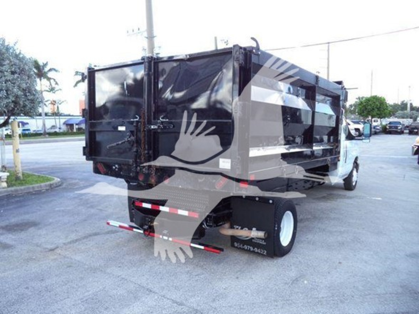 Ford E-450 dumping truck rear view showing dump bed and dual rear tires with stock number T20696.