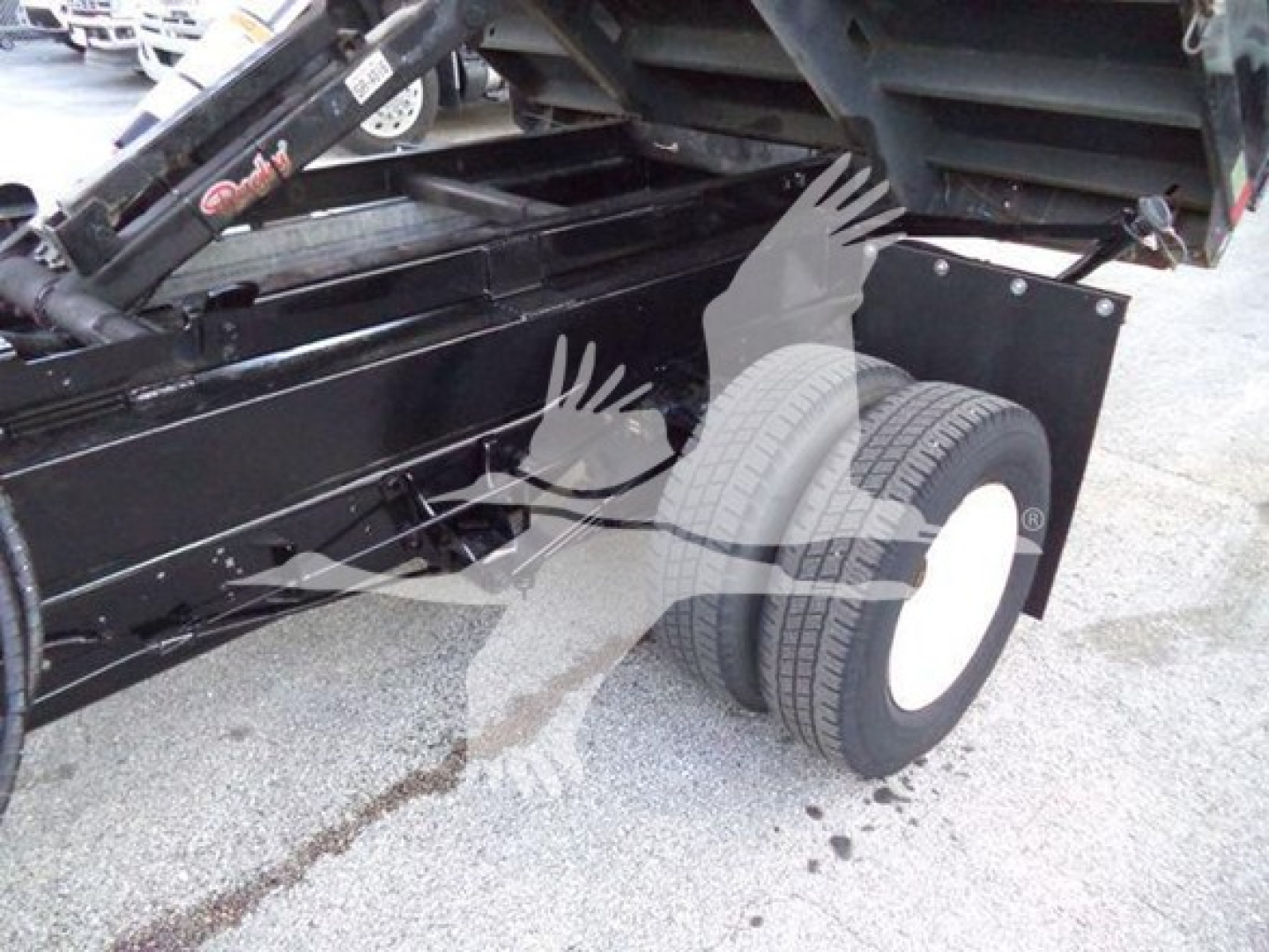 Ford E450 dump truck undercarriage showing dual rear wheels and dump bed linkage.