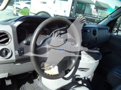 Ford E-Series dashboard and steering wheel in cab with center console and gauges visible