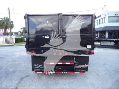 Truck dump bed rear view with TLC decals and reflective rear bumper, Ford E-450 chassis, black cargo body, urban lot.