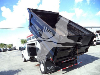 Ford E450 dump truck with a raised black dump bed and white cab, side view showing the rear; VIN 1FDXE4FS4BDB20696 and stock T20696