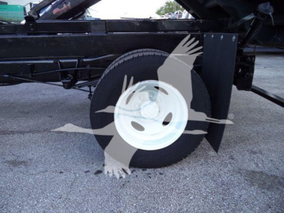 Ford E450 dump truck side showing rear wheel and hydraulic lift components