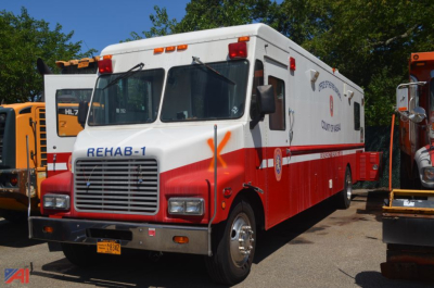 Front three-quarter view of a white and red 1990 Chevrolet P60 Forward Control chassis ambulance/command truck with REHAB-1 text on grille and ambulance graphics.