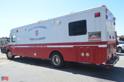 Chevrolet P60 forward-control fire rescue vehicle with Nassau County Office of the Fire Marshal markings, emergency lights, and red and white livery, rear view.