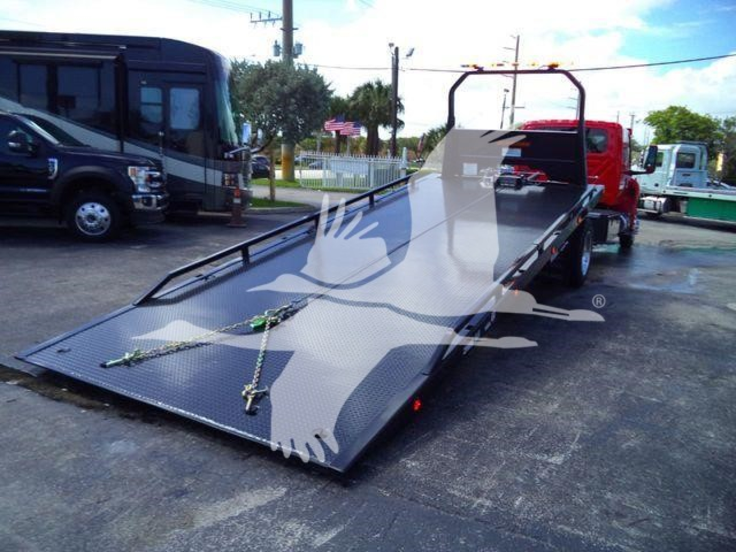 Truck bed tow rollback w/ ramp extended showing loading deck and strap anchors.