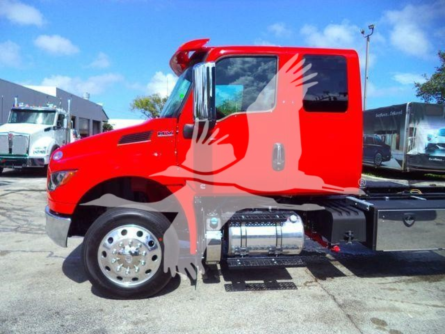 International MV truck cab side view showing red color, chrome fuel tank, and steps.