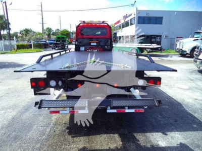 Flatbed tow truck in-service rear view showing MV607RED stock image, rollback truck with platform open and lights, International badge not visible.