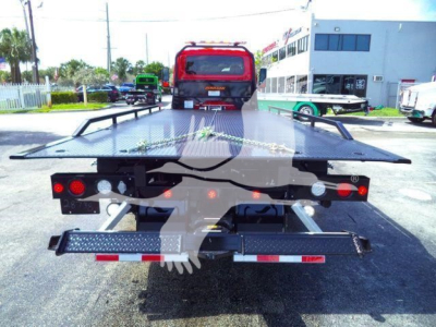 Tow truck rollback bed with diamond plate platform and rear bumper, seen from the rear showing taillights and modular hinge assemblies.