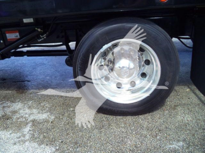 Wheel and tire close-up of a new 2027 International MV rollback truck showing chrome hub and black tire undercarriage.