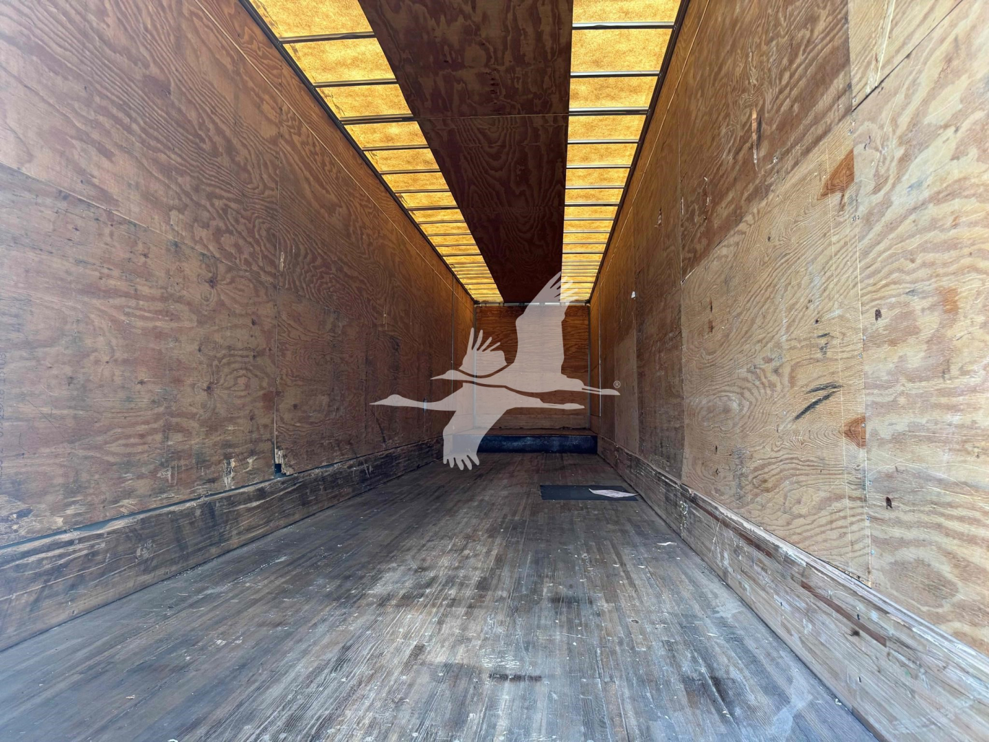 Interior of a 2015 Manac sheet post 48' drop van trailer showing wooden sidewalls and floor, with light panels along the ceiling.