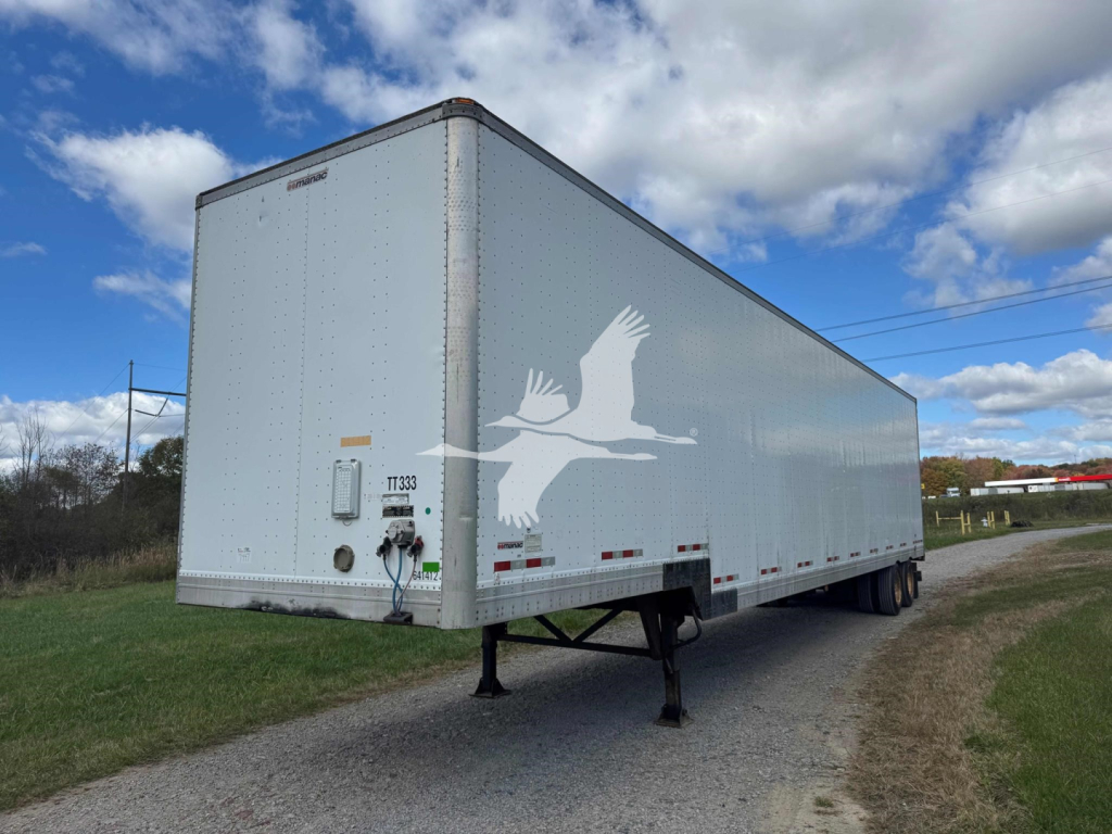 Manac 48' sheet and post drop trailer in-service showing front left side and landing gear with VIN sticker visible.