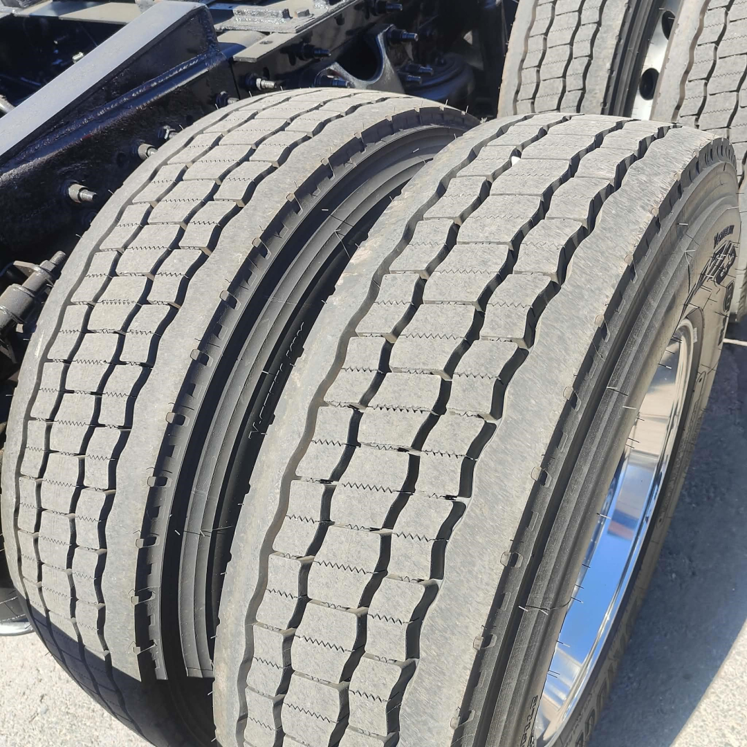 Truck axle dual tires on an International LT chassis showing treaded tires and chrome wheel