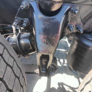 Front underside view of a 2021 International LT truck front suspension hitch assembly with bolts and U-bolts visible