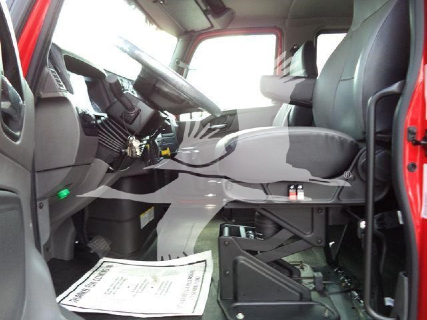 Truck cab interior showing driver's seat and dashboard of a new International MV rollback truck.