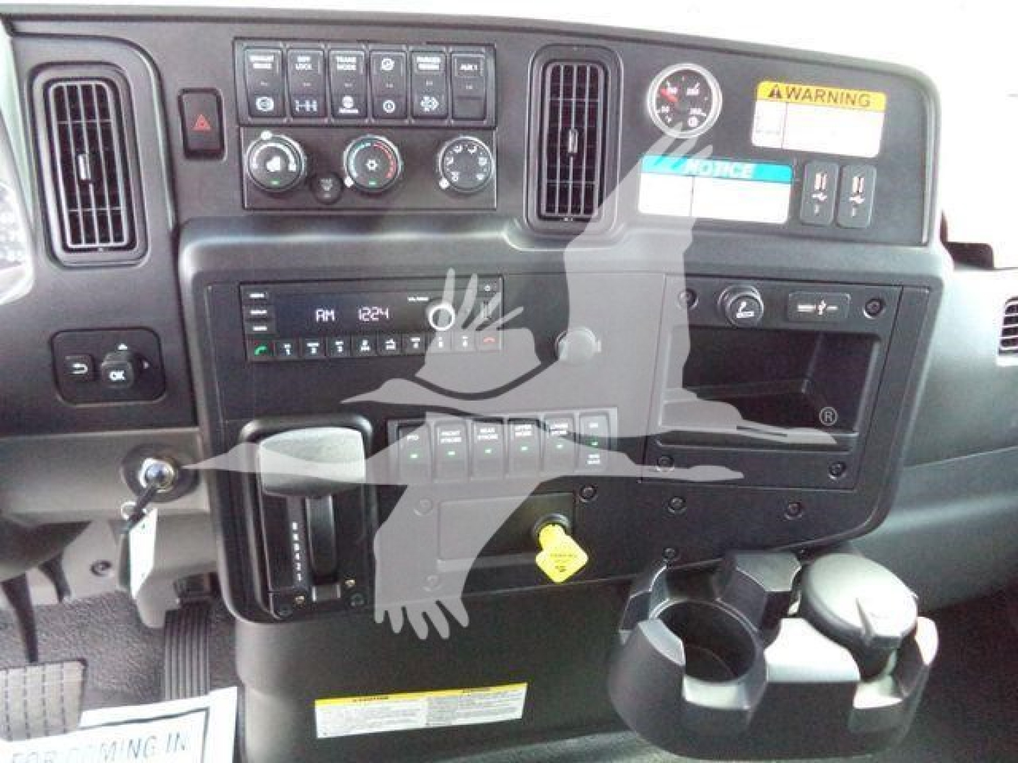 Trucks dashboard interior showing radio, climate controls, storage compartments, cup holders, and ignition area.
