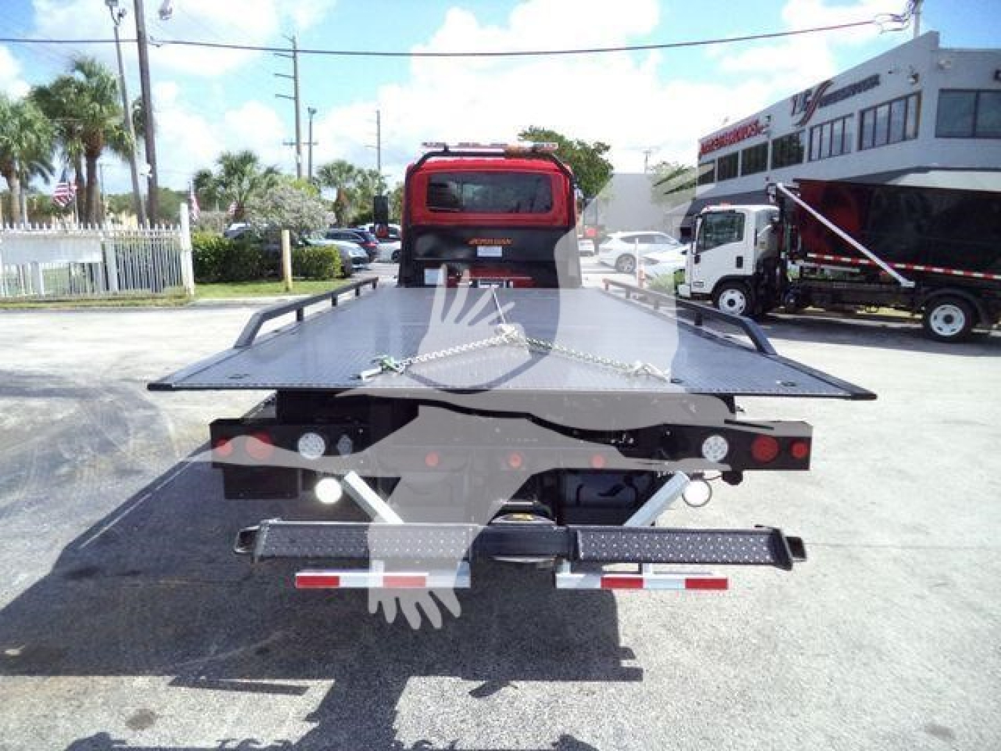 Tow truck flatbed/dolly bed showing rear view with tail lights and rear bumper, International MV 2027 stock image.