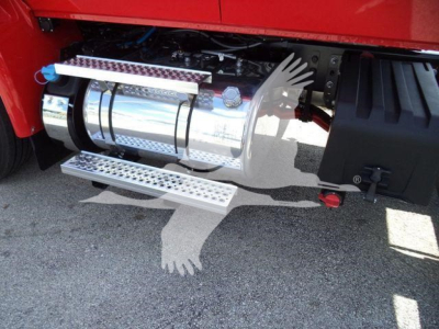 Tractor-trailer side showing polished chrome exhaust/power unit with metal steps and black fender, part of a new 2027 International MV rollback truck.