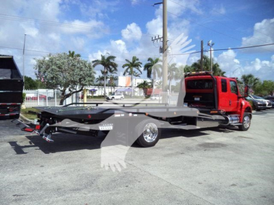 MV-series truck in service bay showing a rollback tow truck with a low flatbed and red cab, side view with hydraulic winch and rear equipment.