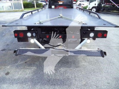 Rear view of a black rollback tow truck flatbed with taillights, safety chains, and dual support arms extending from the frame.