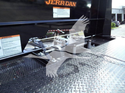 Truck bed platform with attachment hitch and metal diamond-plate surface; stickered labels and 'JERR-DAN' logo on the side of a rollback truck.