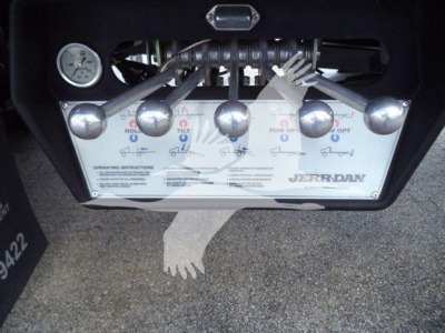 Panel with controls and gauge on a Jerr-Dan rollback tow truck, showing operating instructions and levers labeled with icons.