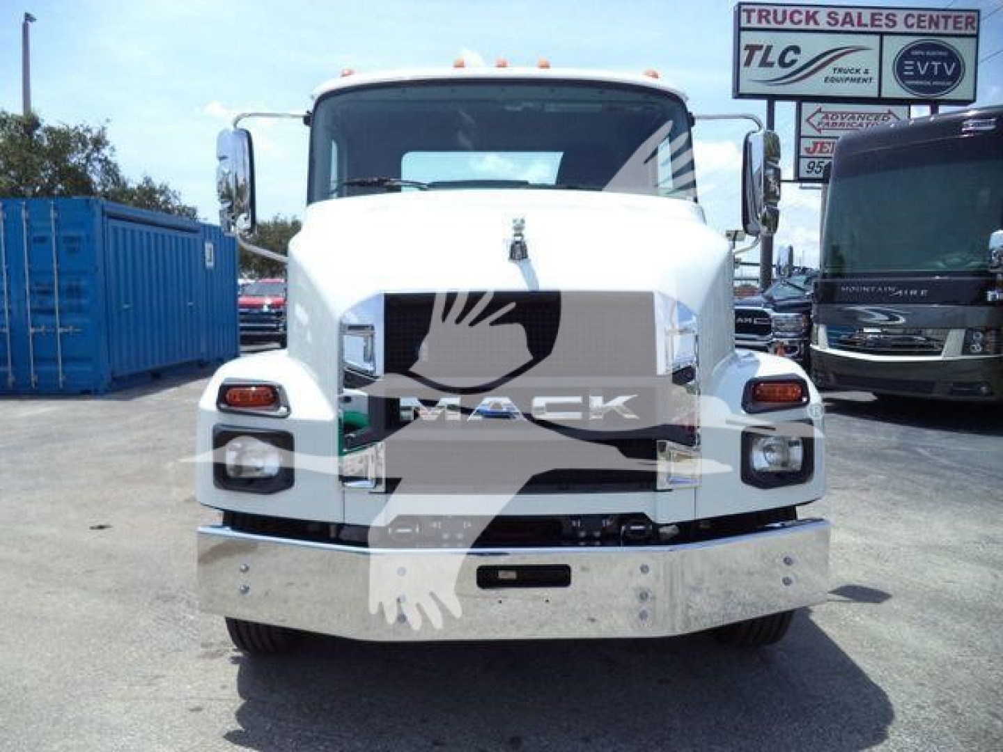 Front view of a white 2025 Mack MD6 truck showing the grille, bumper guard, and side mirrors.