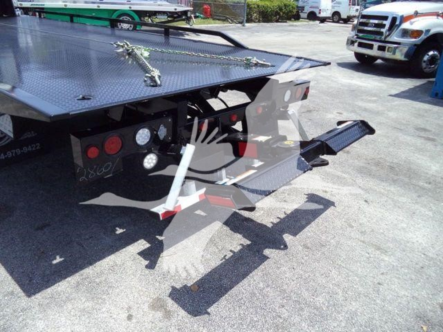 Mack MD6 rollback truck deck and wheel area showing loading ramps and hydraulic components.