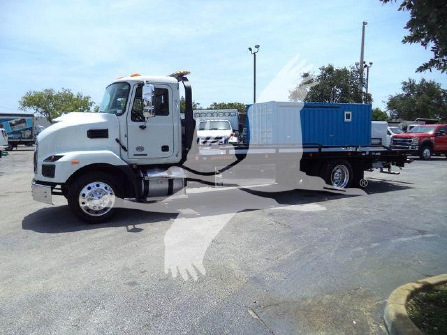 MD6 rollback truck showing cab and blue utility body with storage compartments and generator unit