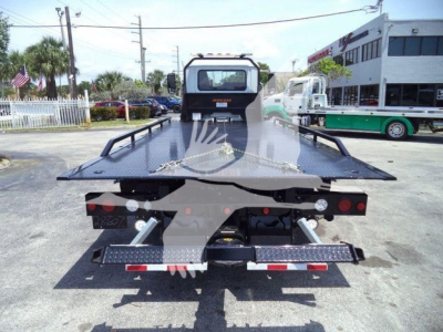 Truck bed of a 2025 Mack MD6 rollback truck showing flatbed with rear bumper and safety rails.