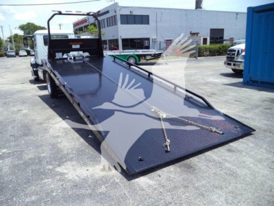 MD/6 tow truck flatbed in-service showing hydraulic roller bed and loading ramp extending from rear.