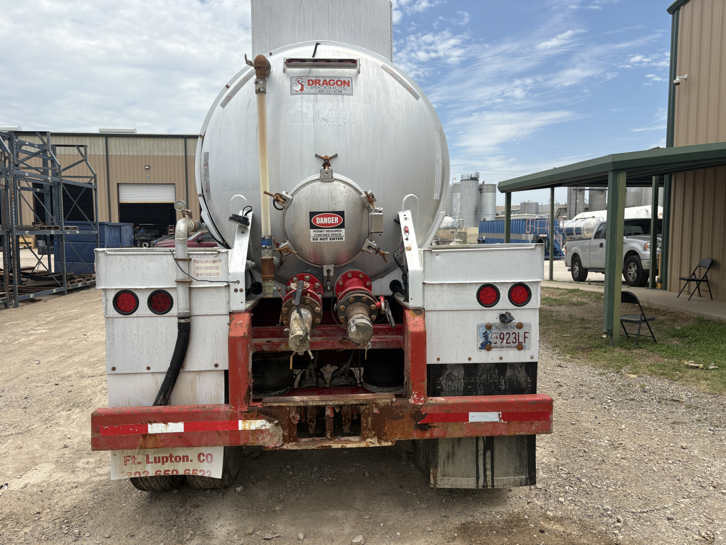 Rear view of a Dragon 150BBL vacuum trailer showing two red and silver valves and discharge hoses, with Dragon branding on the tank.