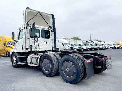 Freightliner Cascadia 116 tractor in a used trucks lot, side and rear view with twin rear axles and fifth wheel seen.