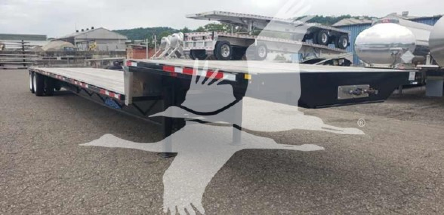 Wabash drop-deck trailer showing tandem drop-closed deck with reflective safety stripes and metal frame.