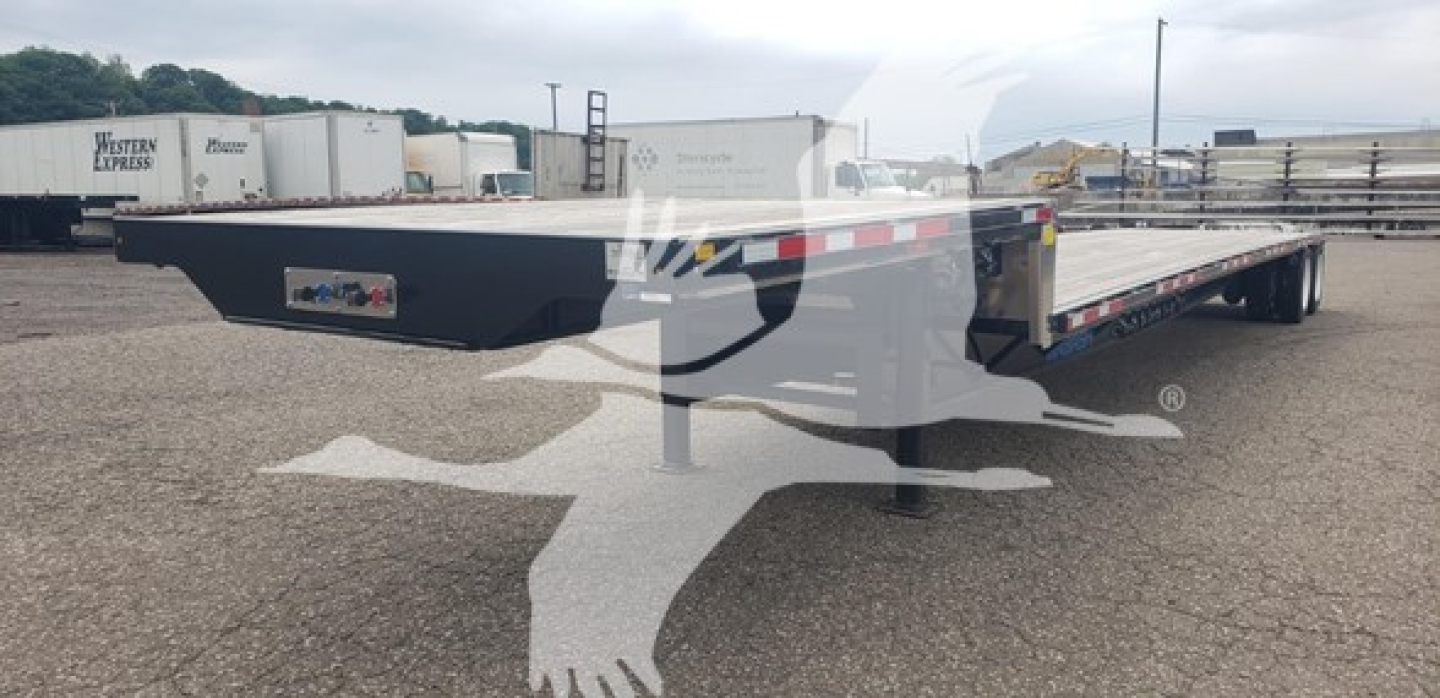 Trailer side view showing a long flatbed drop deck trailer with black painted frame and red/white reflective tape along the edge.